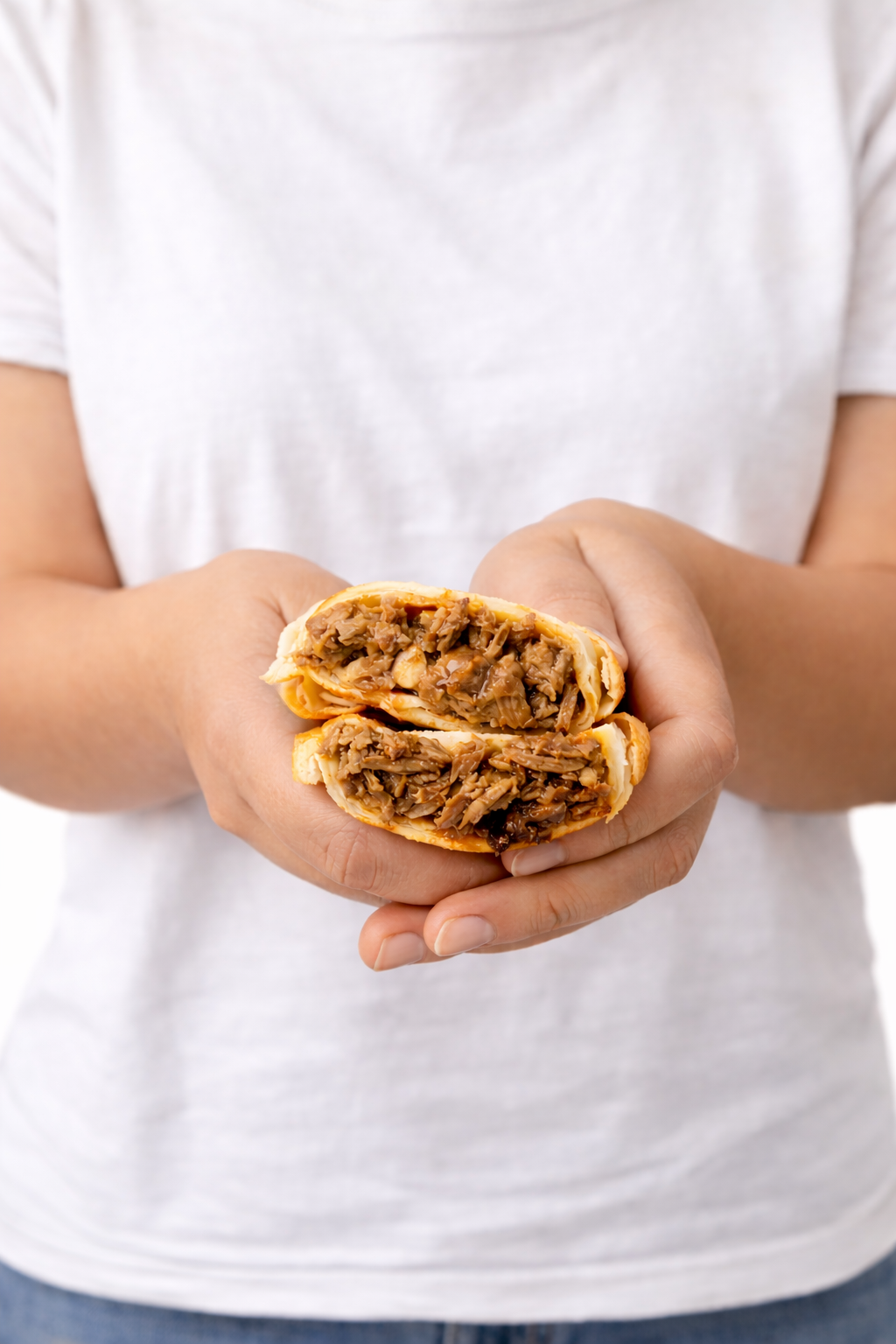 Hands holding a fresh empanada